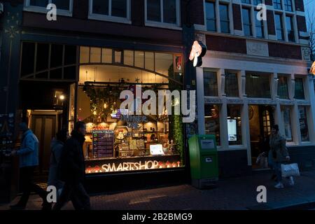 Amsterdam, PAESI BASSI - 25 FEBBRAIO 2020 - Il centro medievale della città è oggi il principale quartiere a luci rosse e il negozio di caffè per il fumo legale Foto Stock