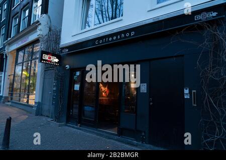 Amsterdam, PAESI BASSI - 25 FEBBRAIO 2020 - Il centro medievale della città è oggi il principale quartiere a luci rosse e il negozio di caffè per il fumo legale Foto Stock