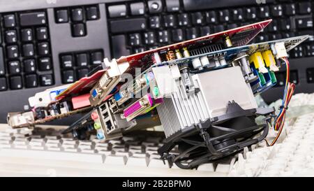 Parti di ricambio hardware e tastiere smontate. Smistamento rifiuti elettronici. Schede grafiche per computer o scheda madre con componenti elettronici, memorie, dissipatore di calore. Foto Stock