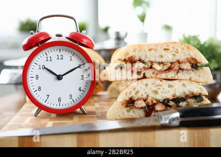 Sveglia rossa con supporti sandwich su tavolo in legno Foto Stock