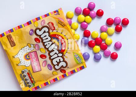 Pacchetto di caramelle Nestle Llama edizione Smarties dolci aperti con contenuti rovesciati set su sfondo bianco - SpectacuLlama Foto Stock