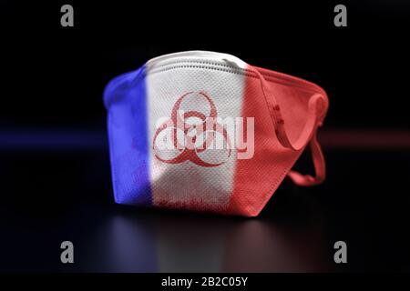 Maschera facciale macchiata di sangue marcata con simbolo di rischio biologico ai colori della bandiera francese, dopo l'epidemia di coronavirus COVID-19 in Francia. Foto Stock