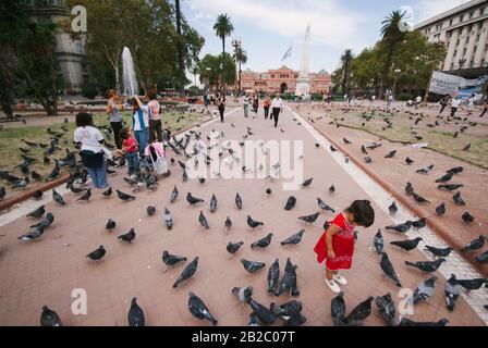 Buenos AIRES, ARGENTINA-7 APRILE: La gente cammina tra un multituta di piccioni nella Plaza de Mayo di fronte alla Casa Rosada il 7th aprile 20 Foto Stock