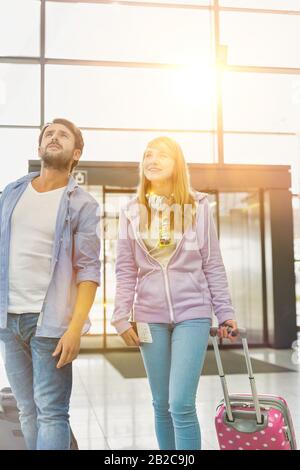 L'uomo maturo che arriva con la sua figlia in aeroporto che cerca il loro pick up Foto Stock