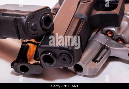 Quattro pistole, due pistole nere a 9mm e un calibro 40 con revolver nero, 38 speciali e una argento, 357 Magnum su sfondo bianco Foto Stock