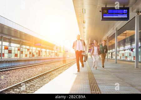 Ritratto di uomini d'affari che corrono per prendere il treno in stazione Foto Stock