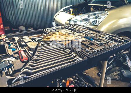 Fissaggio di utensili meccanici a mano in una scatola aperta presso l'officina di riparazione auto in interni Foto Stock