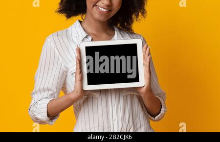 Tablet Digitale Con Schermo Nero Nelle Mani Di Afro Lady Irriconoscibile Foto Stock