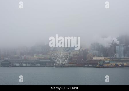 Vista sulla foggy Seattle e sulla Seattle Great Wheel, da un traghetto su Puget Sound. Foto Stock