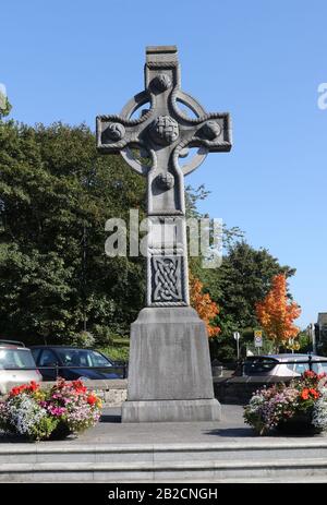 Un moderno incrocio in cemento o un alto incrocio celtico in un parcheggio presso Cathedral Square, Letterkenny in una calda giornata autunnale nella contea di Donegal. Foto Stock