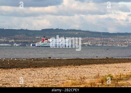 Un traghetto Stena Superfast che naviga oltre Carrickfergus da Belfast Lough in Scozia in un soleggiato pomeriggio d'autunno caldo. Foto Stock