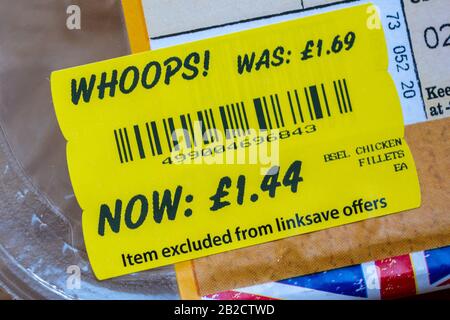 Etichettatura degli alimenti a prezzo ridotto, etichetta gialla del supermercato sulla confezione di pezzi di pollo Foto Stock