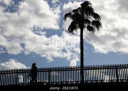 Una persona cammina su un ponte nella città di Valencia, attraversando il parco Turia, in una giornata torbida. Foto Stock