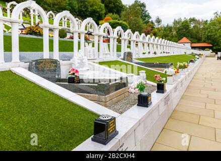 Arcate e tombe commemorative, cimitero di Bryntaf, cimitero di Aberfan, Glamorgan, Galles, luogo di riposo delle vittime che sono morte nel disastro minerario di Aberfan 1966 Foto Stock