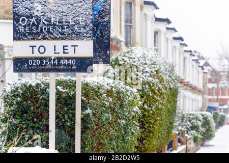 Londra, Regno Unito - 10 dicembre 2019 - Lasciare segno coperto da neve invernale intorno alla zona di West Hampstead con case terrazza sullo sfondo Foto Stock