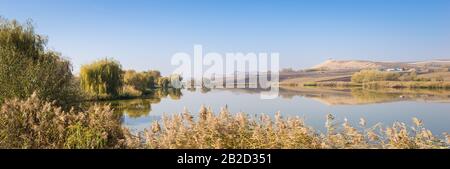 Panorama paesaggio immagine di un lago di pesca vicino al villaggio di Saulia in Transilvania, Europa orientale Foto Stock