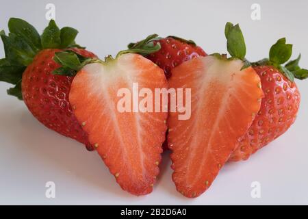 gruppo di fragole isolato su sfondo bianco intero e rotto Foto Stock