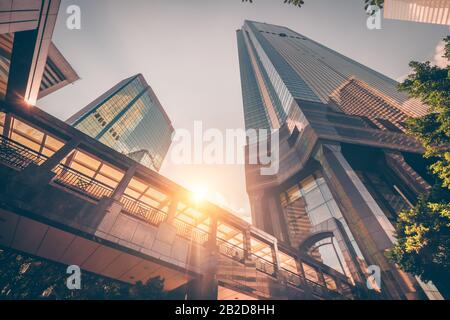 Abstract paesaggio urbano futuristico vista con moderni grattacieli. Sun splende nel cielo di tramonto, riflettendo in vetro della passerella. Architettura urbana ba Foto Stock