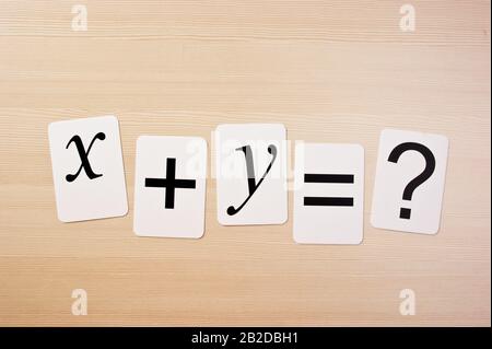 Tessera della scuola con problemi di matematica sul tavolo Foto Stock