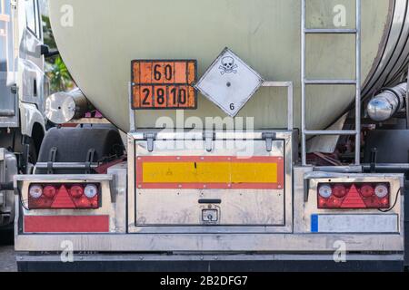 Camion cisterna di merci pericolose con le loro piastre arancioni e etichetta di pericolo tossico Foto Stock