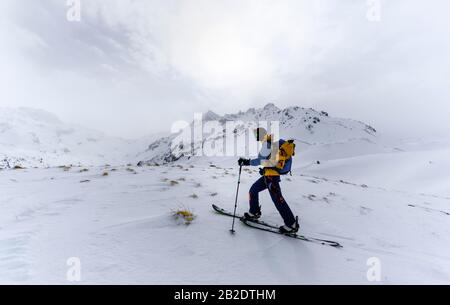 Scialpinismo nella neve in nebbia, dietro le cime della gola, Wattentaler Lizum, Tux Alps, Tirolo, Austria Foto Stock