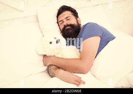 Tanga pigro relax nella camera da letto. Buona notte e dolci sogni. uomo barbuto orsacchiotto a letto. Il giocattolo di peluche concetto. buon compleanno presente. è il momento di andare a dormire. trascorrere il weekend a letto. Confortevole a casa. Foto Stock