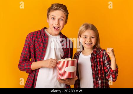 Attività Weekend Dei Fratelli. Joulful Little Brother E Sister Holding Popcorn Bucket Foto Stock