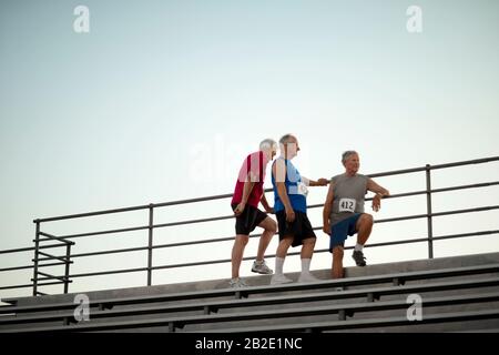 Un gruppo di uomini maturi atletici che si levano in piedi sui bracconieri Foto Stock