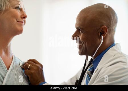 Donna matura che ha il suo battito cardiaco controllato dal suo medico Foto Stock