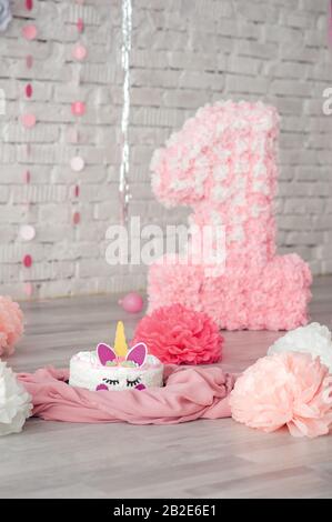 torta unicorno bianca su un pavimento di legno chiaro, in tessuto delicato rosa, compleanno in decor rosa per una bambina Foto Stock