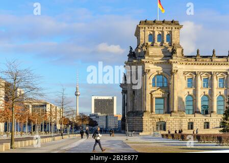 Scenario di fronte a Reichstagsgebäude, edificio del parlamento tedesco, dal parco Platz der Republik e sullo sfondo di Berliner fernsehturm in inverno. Foto Stock