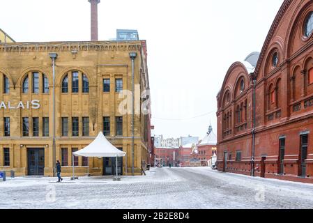 La piazza interna coperta di neve tra il gruppo di edifici industriali in mattoni recentemente ristrutturato centro culturale, Kulturbrauerei, nella stagione invernale. Foto Stock