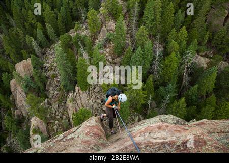 Steffi Moos rappel dalla cima del Matron nei Flatirons sopra Boulder, Colorado. Foto Stock