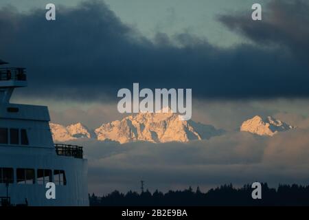 La catena montuosa olimpica attraverso le nuvole all'alba da Seattle Foto Stock