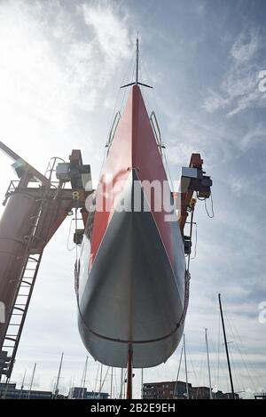 Un moderno yacht da competizione appeso al molo per la manutenzione Foto Stock