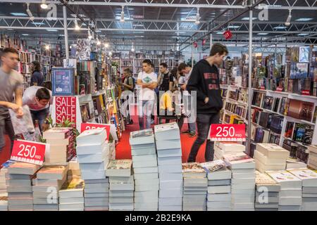 Belgrado, SERBIA - 25 OTTOBRE 2019: Interno di una libreria serba all'ora di punta affollata di persone, lettori, passando con una velocità di sfocatura, e mucchi di o Foto Stock