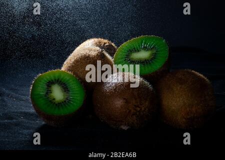 Kiwi con fondo nero e pioggia leggera Foto Stock