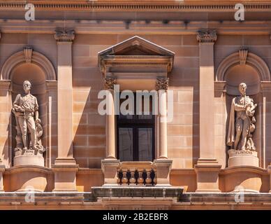 Sydney, Australia - 11 dicembre 2009: Primo piano della facciata in pietra rossa del Dipartimento delle Terre con statue di Hume e Flinders. Foto Stock