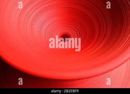 Tessuto plastico avvolgente rosso brillante come sfondo. Foto Stock