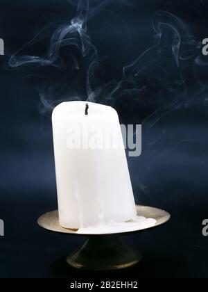 Fumo proveniente da una candela soffiata con sfondo scuro Foto Stock