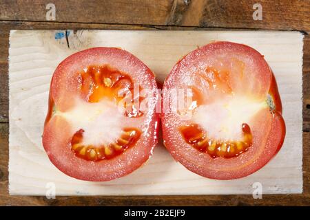 Tomatos freschi su una tavola di legno Foto Stock