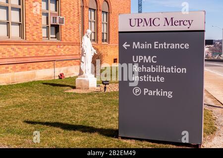 L'UPMC Mercy Hospital firma su Bluff Street nel quartiere Uptown della città con una statua di Gesù sullo sfondo, Pittsburgh, PA, USA Foto Stock