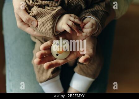 il bambino tiene un succhietto nelle braccia della madre Foto Stock