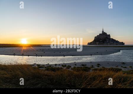 Tramonto a Mont Saint Michel come la marea arriva in Normandia, Francia Foto Stock