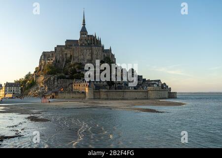 Tramonto come la marea arriva a Mont Saint Michel, Normandia, Francia Foto Stock