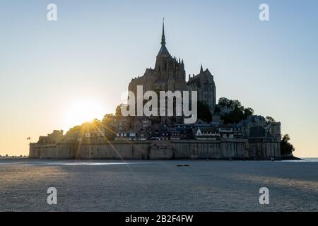 Tramonto come la marea arriva a Mont Saint Michel, Normandia, Francia Foto Stock