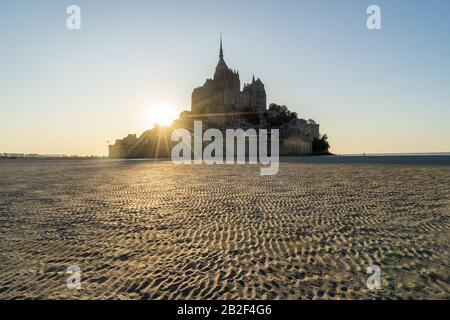 Tramonto come la marea arriva a Mont Saint Michel, Normandia, Francia Foto Stock