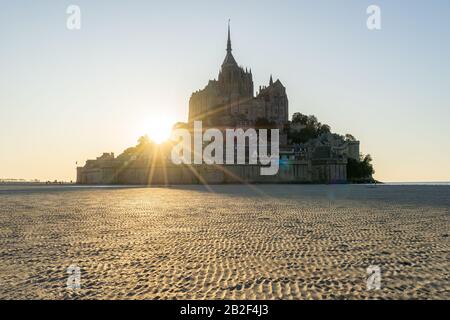 Tramonto come la marea arriva a Mont Saint Michel, Normandia, Francia Foto Stock