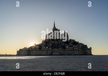 Tramonto come la marea arriva a Mont Saint Michel, Normandia, Francia Foto Stock