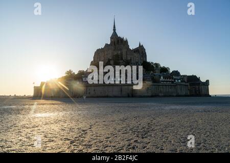 Tramonto come la marea arriva a Mont Saint Michel, Normandia, Francia Foto Stock